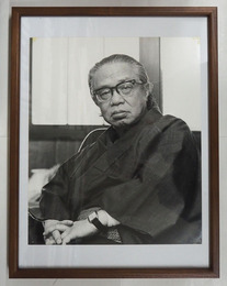 松本清張肖像写真額　モノクロ　裏面に文藝春秋のゴム印有　写真３０４×２５４ミリ　四方角にテープ跡有