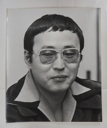 丸山健二肖像写真　モノクロ　裏面に文藝春秋のゴム印有　３０４×２５４ミリ　四方角にテープ跡有
