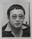 丸山健二肖像写真　モノクロ　裏面に文藝春秋のゴム印有　３０４×２５４ミリ　四方角にテープ跡有