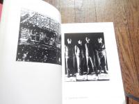 ギルバート＆ジョージ展目録/GILBERT AND GEORGE: ART FOR ALL 1971-1996.現代イギリス美術界の異才
 出版社 セゾン美術館/Sezon Museum of Art
刊行年 1997
ページ数 189 with numerous col. and monochro. illus.
サイズ 25 x 19/Printed boards 
ギルバート・プロッシュ（Gilbert Prousch、イタリア出身、1943年9月17日 - ）とジョージ・パサモア（George Passmore、イギリス出身、1942年1月8日 - ）の二人組であり、常にペアで創作活動をしているため、"ギルバート&ジョージ"として知られている。風変わりで時に攻撃的な作品から、常に物議を醸している現代美術家である。

ギルバートはイタリアのボルツァーノ自治県サン・マルティーノ・イン・バディーア出身で、オーストリアとミュンヘンでアートを学んだ後にイギリスに渡った。ジョージはイングランドのプリマス生まれ。二人はロンドン芸術大学のセントラル・セント・マーチンズで彫刻を学んでいる時に出会った。二人はゲイのカップルだと言われているが、プライベートは明かさないので定かではない。

ジョージ&ギルバートはパフォーマンス・アーティストとして知られている。彼らの学生時代の作品として"The Singing Sculpture"（歌う彫刻）があるが、これは自分自身を金箔で覆い、Flanagan and Allenの曲に合わせて何時間もテーブルの上でマイムをするというものであった。ギルバートとジョージはパフォーマンスなど作品発表や公衆の場に現れる際はいつも同じようなビジネス・スーツを着て、ほとんどいつも二人一緒に行動している。スーツはイギリス人らしさであると同時に、普通の人の普通の生活の象徴でもある。2人のすることはすべてアートだという事で、自分自身を生きる彫刻、"living sculptures"と称している
