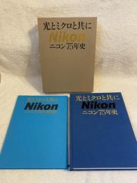 光とミクロと共に　ニコン75年史　2冊揃　（本編・資料集）
 75年史編纂委員会 編纂
    出版社 ニコン
    刊行年 平成5 光とミクロと共に : ニコン75年史. [本編・資料集] / 75年史編纂委員会編纂

 	日露戦争直後から測遠機、測距儀などの光学機械の国産化が求められ、各社で開発が進む。潜水艦製造を要請された三菱合資会社の岩崎小弥太は、東京計器(現トキメック)の光学計器部と岩城硝子の探照灯反射鏡部門を分離して1917年日本光学工業(株)を設立。戦後は民需に転換し、1988年(株)ニコンと社名変更。映像・情報、産業機器、健康・医療の3事業分野で活動を展開。